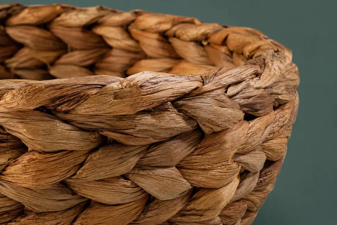 The weave and rim of ON-B-07 in close-up. Plaited strands worked over a wire-free coil; the plait closes at the back under the rim.