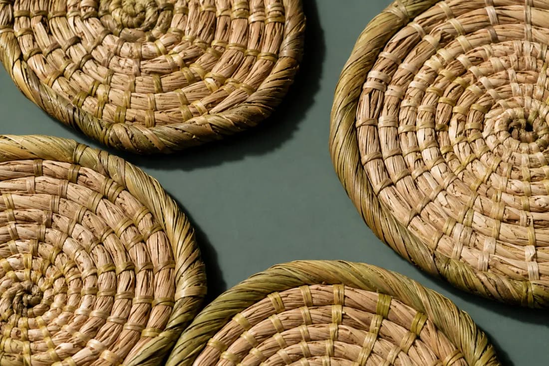 The weave and rim of ON-F-01 in close-up. Each coaster is coiled from its own centre; all four tails are bound off on the underside.