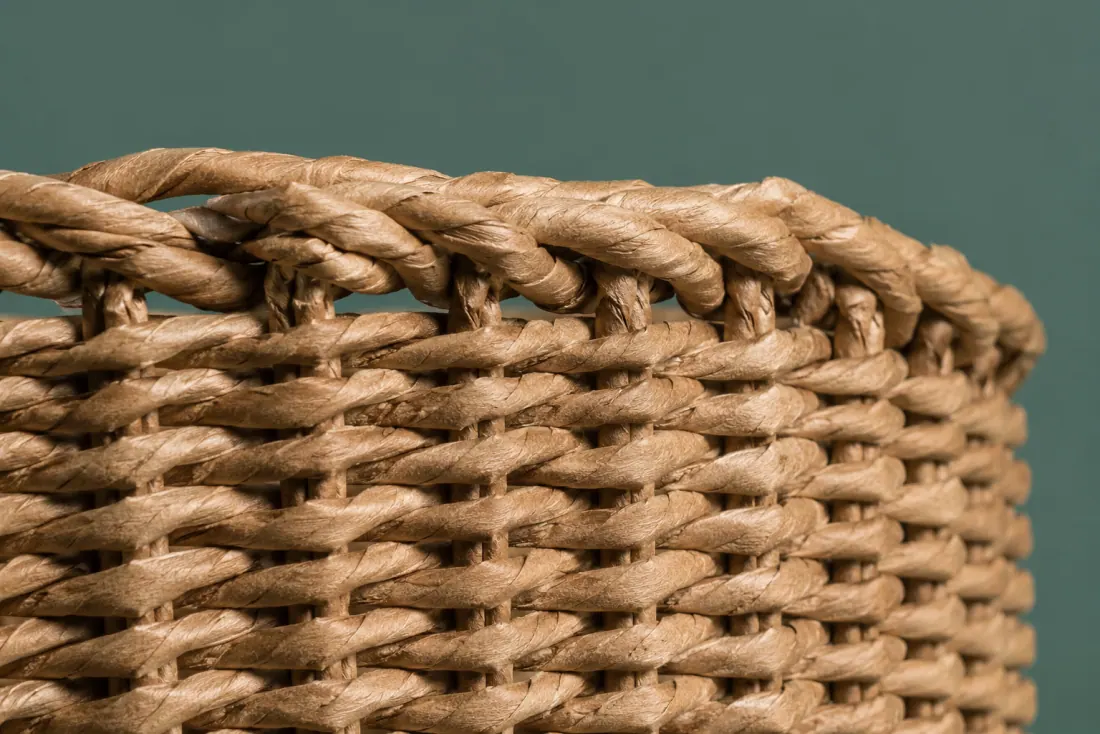 The weave and rim of ON-A-13 in close-up. Twined over paper-cord stakes; the weave closes at the back and the stake ends are folded inward under the rim.