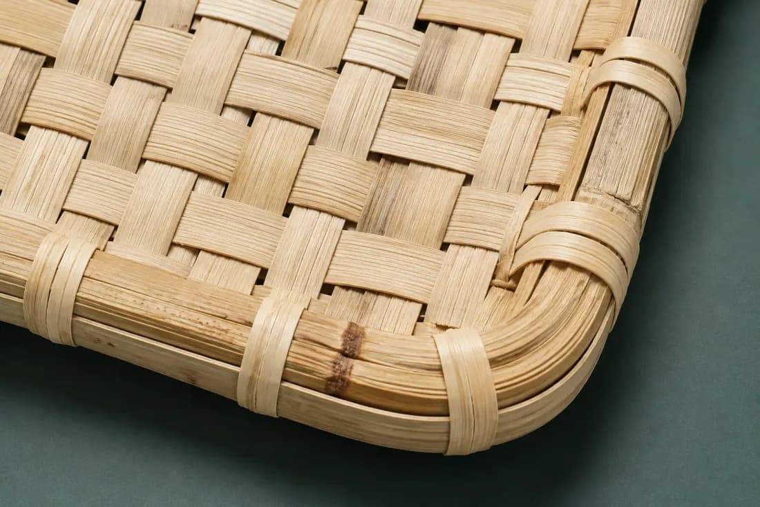 The weave and rim of ON-B-04 in close-up. Plain weave with the warp running the long axis; the strips close along the right short edge.