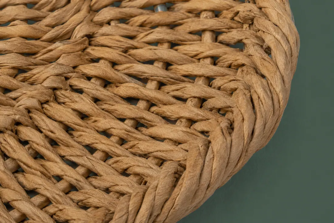 The weave and rim of ON-B-10 in close-up. Twined over radial paper-cord stakes; the weave closes at the front and stake ends fold under.