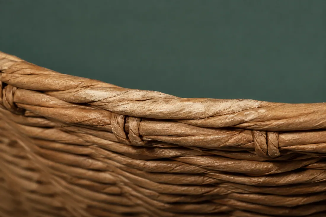 The visible flaw on ON-B-10: The paper skin is scuffed pale along a 40 mm arc of the rim. One stake end shows through the underside weave.