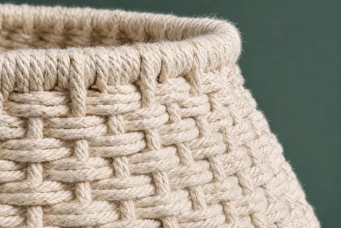 The weave and rim of ON-C-06 in close-up. Cord wound over a former from the top ring down; the tail is sewn into the lower edge at the back.