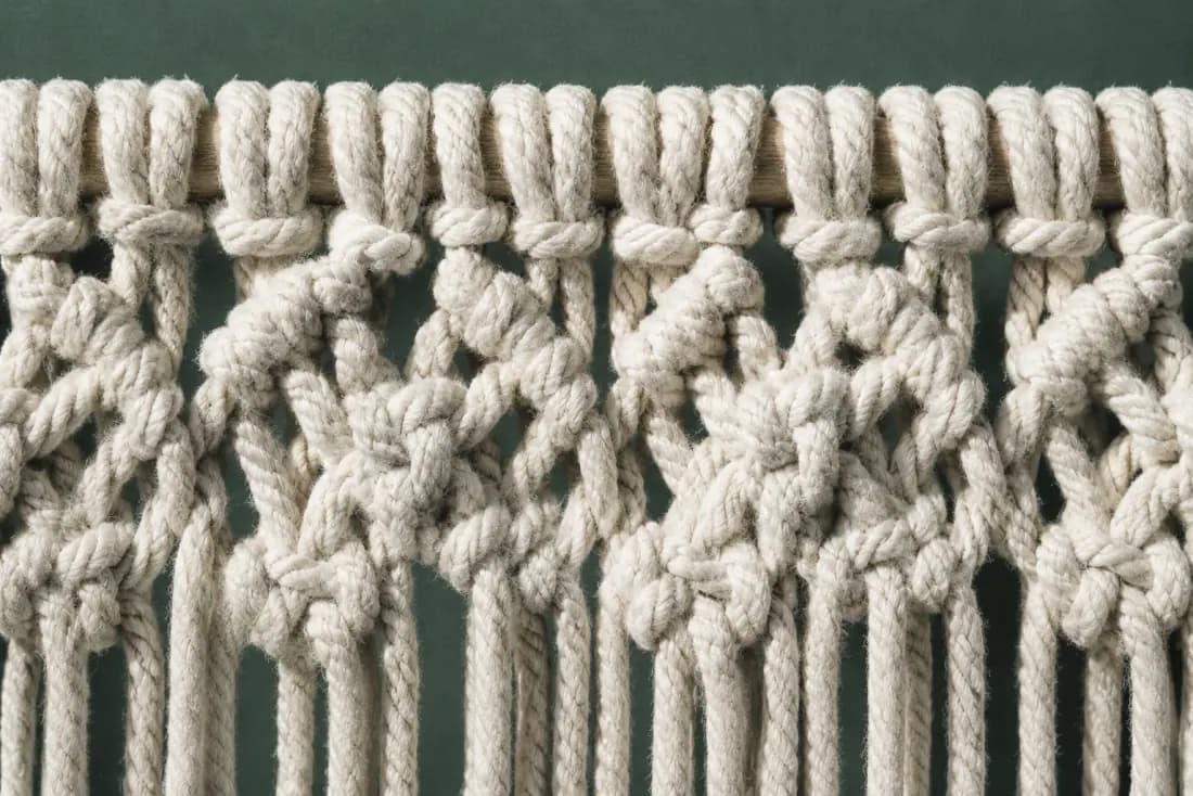 The weave and rim of ON-D-05 in close-up. Knotted downward from the rail in four sinnets; the fringe is cut in a single pass across the bottom.