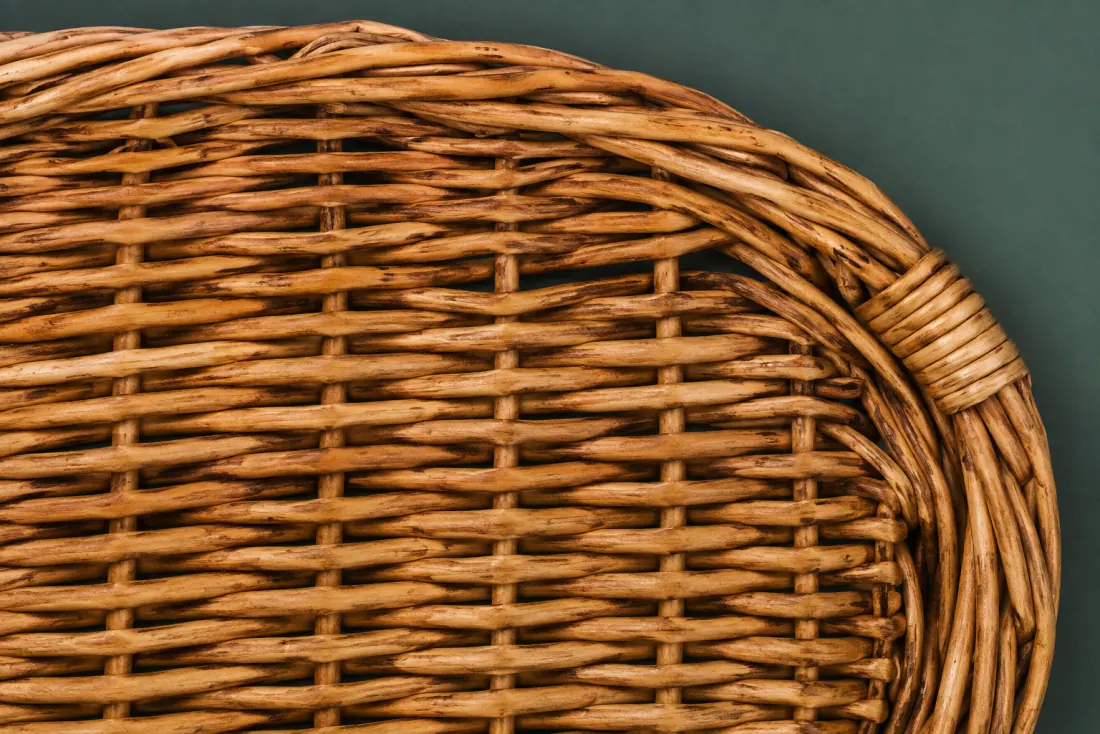 The weave and rim of ON-E-04 in close-up. Slath laid across the short axis; two hinged lid leaves close on the long-axis centreline.